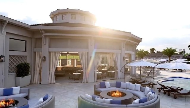 view of patio with an outdoor living space with a fire pit