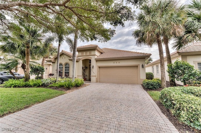 mediterranean / spanish house with a front yard and a garage