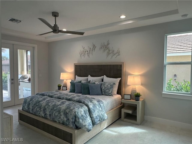 bedroom with ceiling fan, multiple windows, a raised ceiling, and access to outside