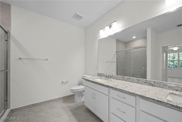 bathroom featuring toilet, ceiling fan, a shower with shower door, and vanity