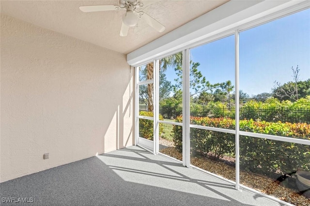 unfurnished sunroom featuring ceiling fan