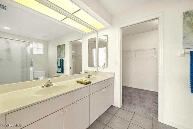 bathroom with vanity, tile patterned flooring, a shower with shower door, and toilet