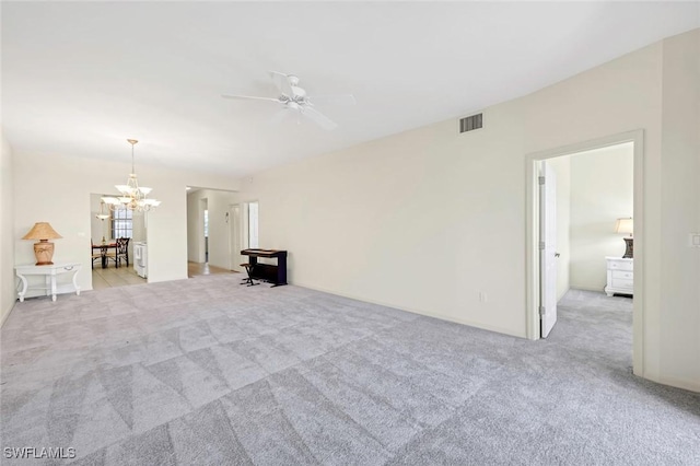 interior space featuring ceiling fan with notable chandelier and light colored carpet