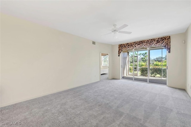 spare room featuring light carpet and ceiling fan