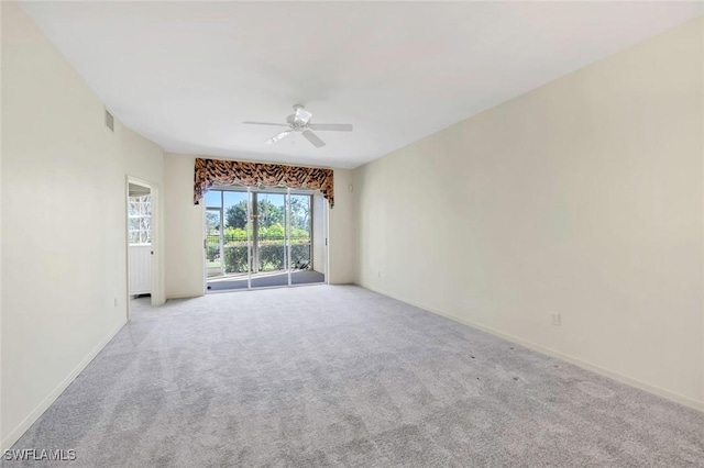 carpeted spare room with ceiling fan