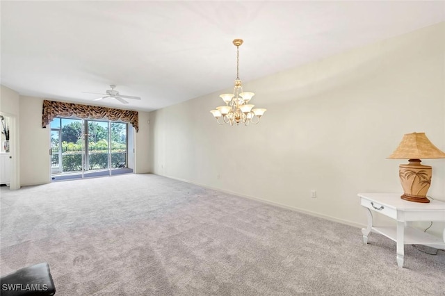 empty room with ceiling fan with notable chandelier and light carpet