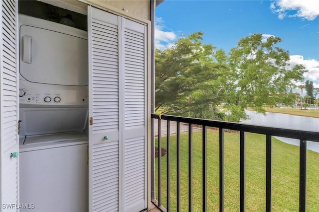 washroom featuring a water view and stacked washer / dryer