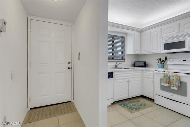 kitchen featuring sink, white appliances, white cabinetry, and light tile patterned flooring