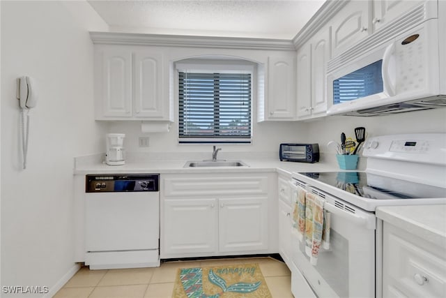 kitchen with white cabinets, sink, light tile patterned flooring, and white appliances