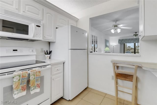 kitchen featuring light tile patterned floors, ceiling fan, white appliances, a textured ceiling, and white cabinets