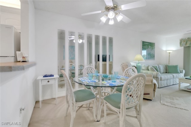 dining area with light carpet and ceiling fan