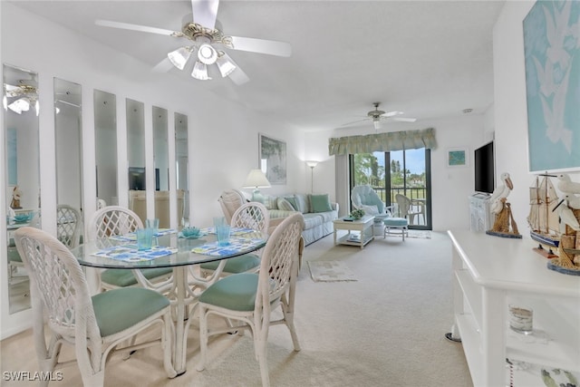 dining space featuring ceiling fan and light colored carpet