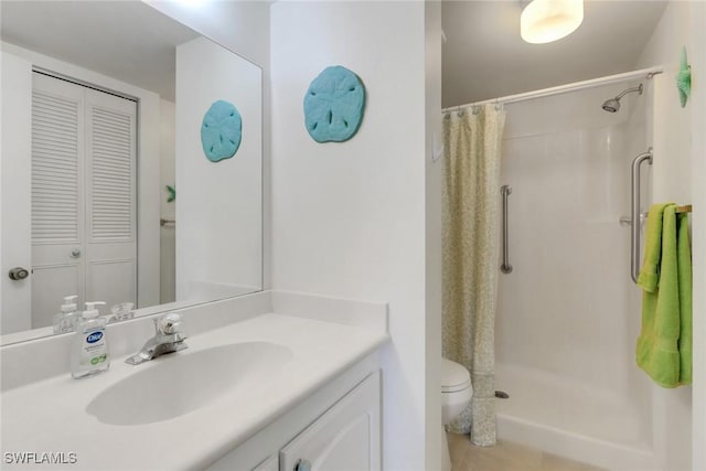 bathroom with toilet, vanity, tile patterned floors, and walk in shower