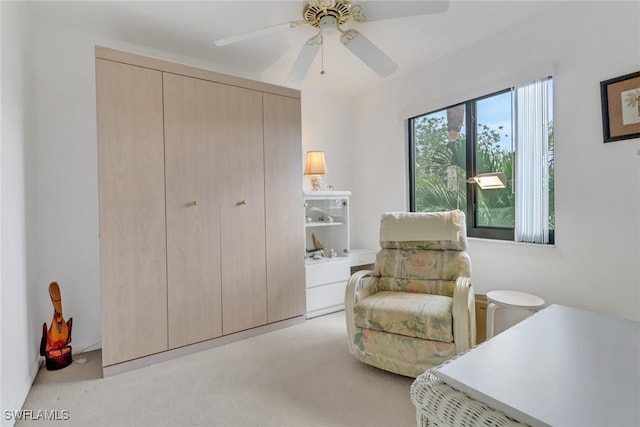 living area featuring ceiling fan and light colored carpet