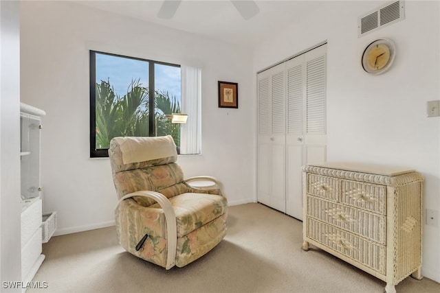 living area with ceiling fan and carpet