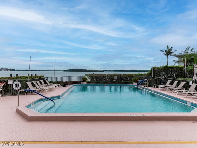 view of pool featuring a patio area and a water view