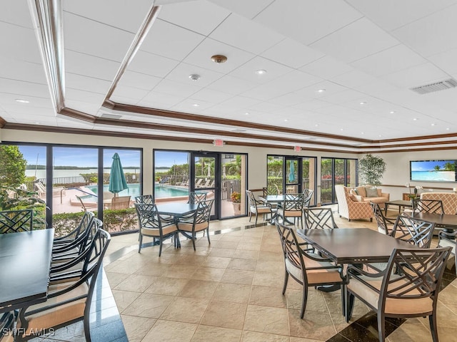 dining room with a raised ceiling, french doors, plenty of natural light, and crown molding