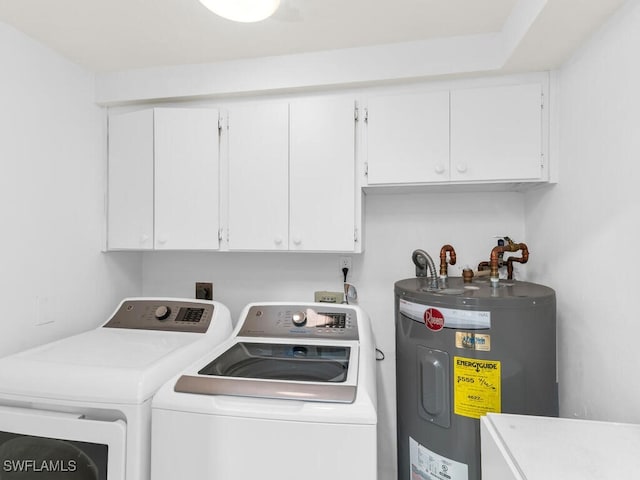 laundry area with electric water heater, independent washer and dryer, and cabinets