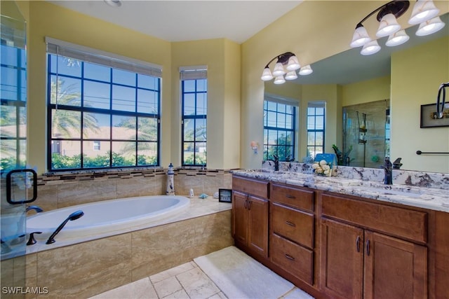 bathroom with tile patterned flooring, vanity, a healthy amount of sunlight, and separate shower and tub