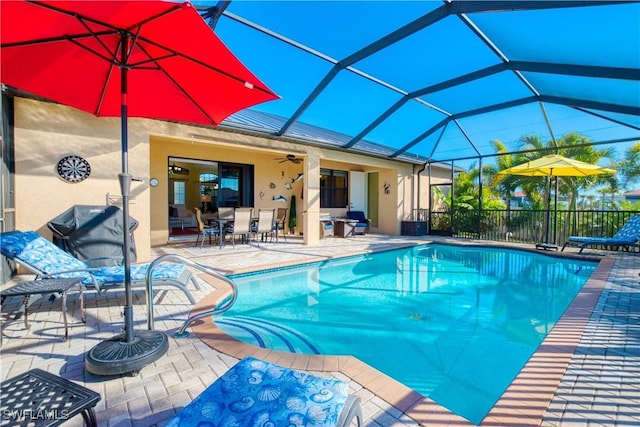 view of pool featuring a grill, a patio, ceiling fan, and glass enclosure