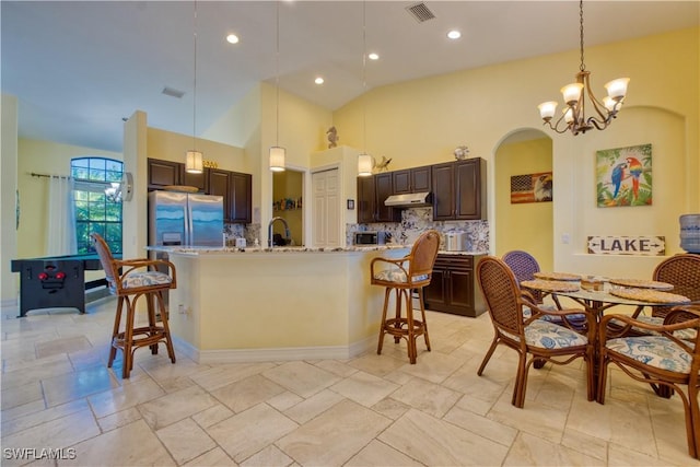 kitchen featuring dark brown cabinetry, stainless steel appliances, a kitchen breakfast bar, and a center island with sink