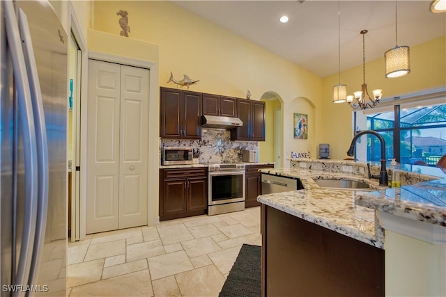 kitchen with sink, hanging light fixtures, stainless steel appliances, dark brown cabinetry, and decorative backsplash