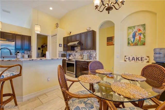 dining space with light tile patterned flooring, an inviting chandelier, sink, and vaulted ceiling