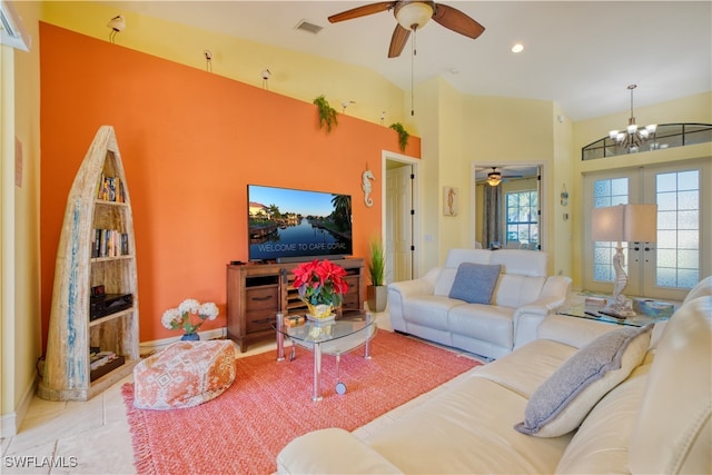 living room with french doors, vaulted ceiling, ceiling fan with notable chandelier, and light tile patterned flooring