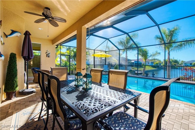 view of patio with a fenced in pool, ceiling fan, and glass enclosure