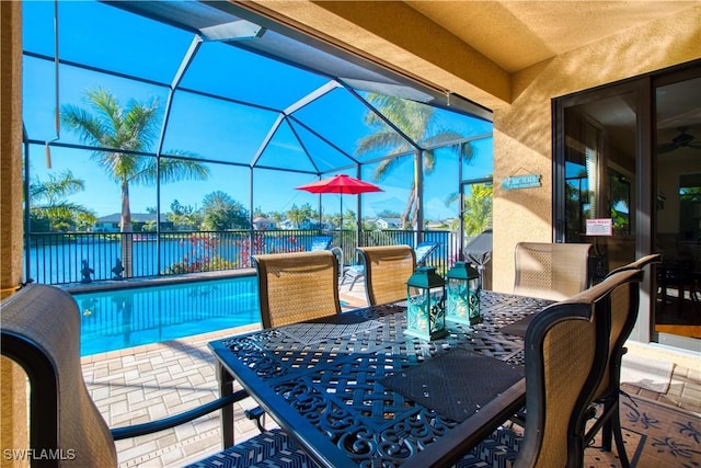 view of patio featuring a water view and glass enclosure