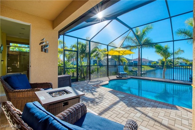 view of swimming pool with a lanai, an outdoor living space with a fire pit, and a patio area