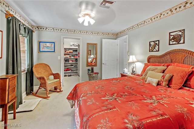 bedroom featuring a ceiling fan, visible vents, carpet floors, a spacious closet, and a closet