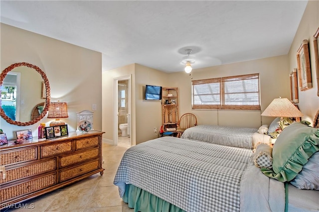 bedroom with ceiling fan, light tile patterned floors, and ensuite bath