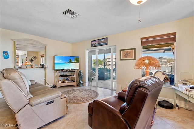 tiled living room featuring visible vents and baseboards