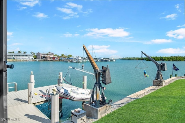 view of dock with a yard, a water view, and boat lift