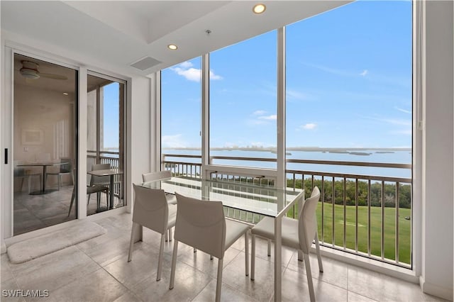 sunroom / solarium featuring a water view