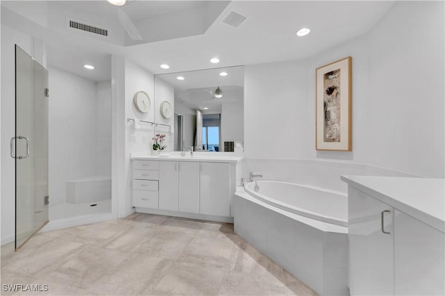 bathroom featuring vanity and independent shower and bath