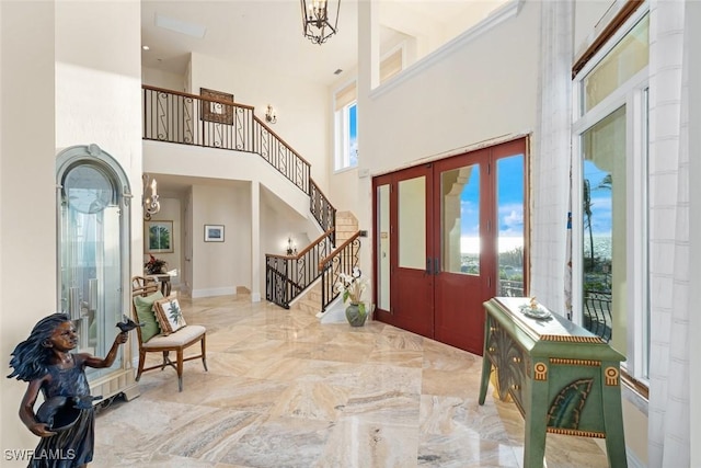 foyer with french doors, a notable chandelier, and a high ceiling