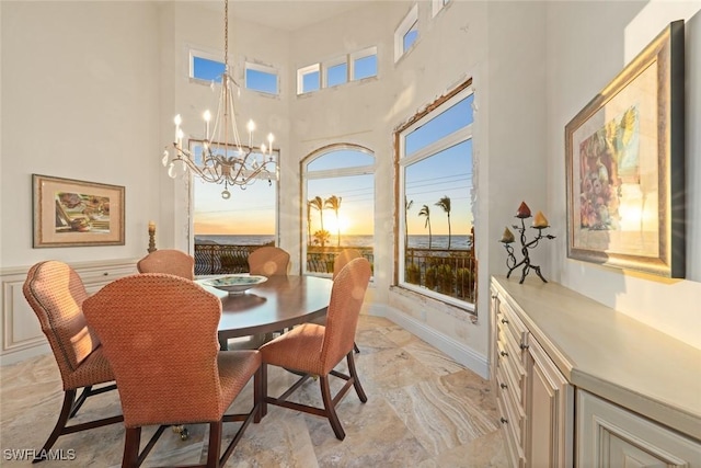 dining room with a chandelier and a high ceiling