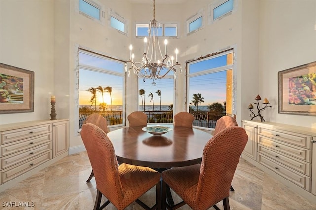 dining room featuring a notable chandelier and a high ceiling