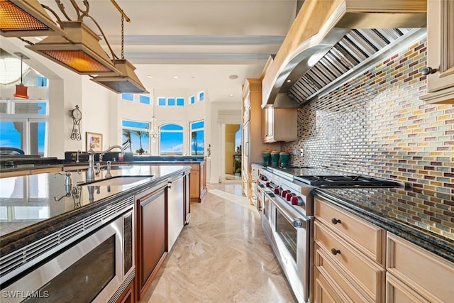 kitchen featuring custom exhaust hood, stainless steel appliances, dark stone counters, sink, and backsplash