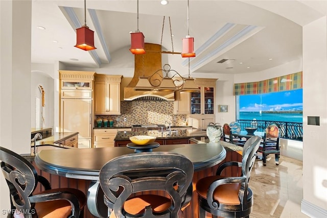 kitchen featuring decorative backsplash, sink, light brown cabinetry, and pendant lighting