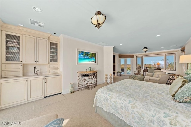 carpeted bedroom with sink and ornamental molding