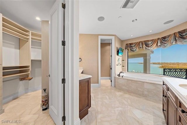 bathroom with a relaxing tiled tub and vanity