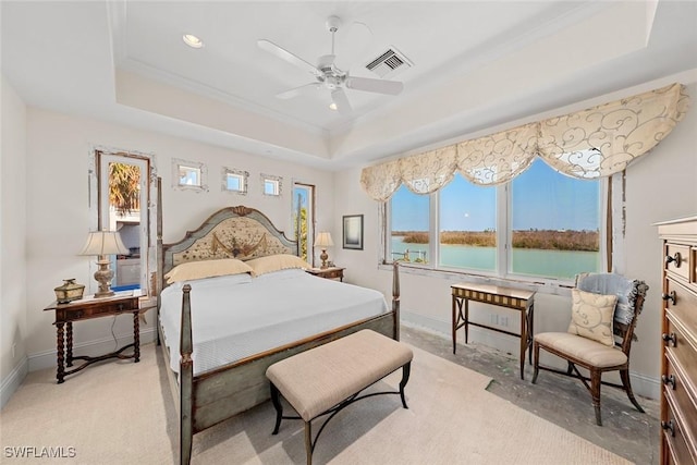 carpeted bedroom with ceiling fan, crown molding, a water view, and a raised ceiling