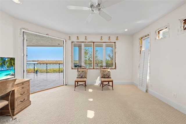 sitting room featuring ceiling fan and light colored carpet