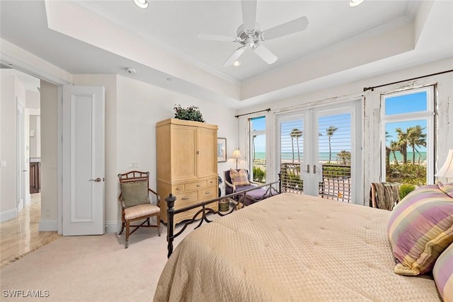 bedroom featuring ceiling fan, access to exterior, a raised ceiling, and french doors