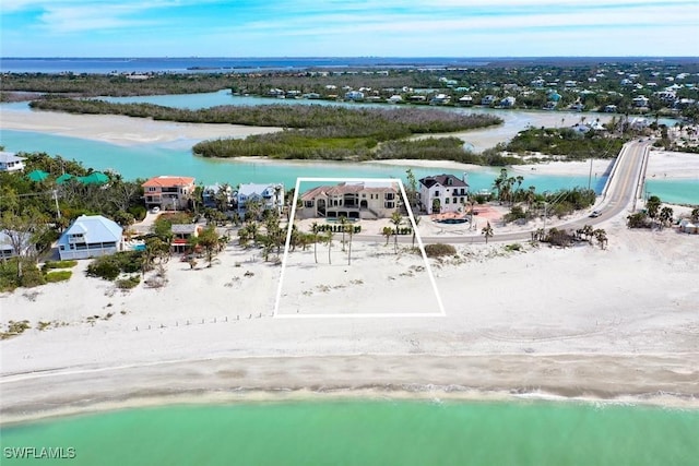 birds eye view of property with a water view and a view of the beach