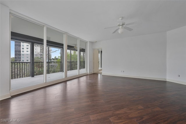 unfurnished room featuring expansive windows, ceiling fan, and dark wood-type flooring