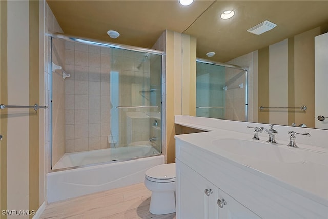 full bathroom with vanity, combined bath / shower with glass door, and toilet